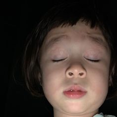 a young child sleeping with his eyes closed