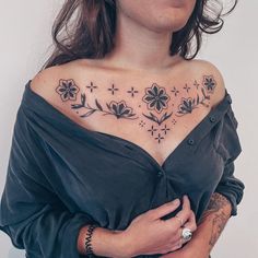 a woman with tattoos on her chest and shoulder