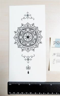 the back side of a card with an intricate design in black ink on white paper