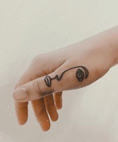 a person's hand with a small tattoo on their left wrist and the word love written in black ink