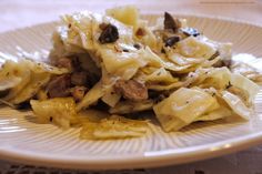 a white plate topped with pasta and meat