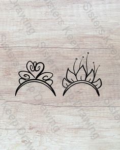 two tiaras are shown on the side of a wooden surface, with black ink