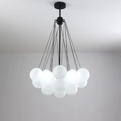 a chandelier hanging from the ceiling in a room with white walls and flooring