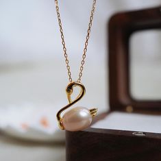 This beautiful swan pearl necklace is a perfect symbol of elegance and grace. Featuring a stunning freshwater pearl cradled in a delicate gold swan frame, this necklace captures the timeless beauty of both the swan and the pearl. The detailed swan design is highlighted with a tiny cubic zirconia in the eye, adding a touch of sparkle to this classic piece. This necklace is perfect for anyone who loves nature-inspired jewelry or minimalist designs. Whether you're wearing it to dress up or down, th Swan Jewelry, Swan Design, Gold Swan, Meaningful Gifts For Her, Beautiful Swan, Chit Chat, Necklace Pearl, Nature Inspired Jewelry, Pearl Jewelry