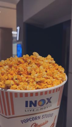 a bucket filled with popcorn sitting on top of a table