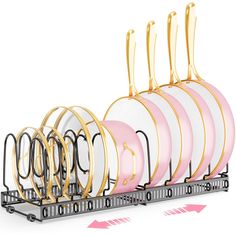 a rack with pink and white plates on it next to two gold - plated forks