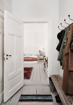 an open door leading to a bedroom with white walls