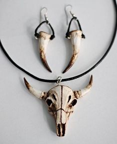 three pieces of animal skull jewelry on a black cord