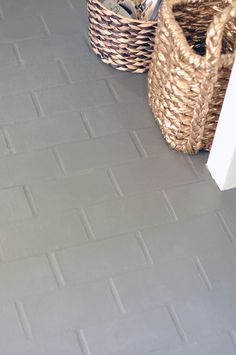 two baskets sitting on the floor next to each other in front of a door way