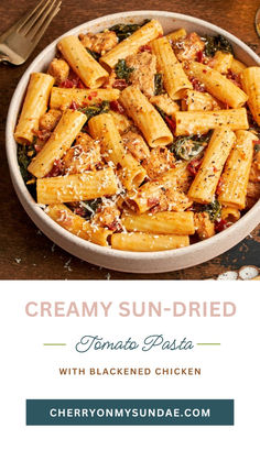 creamy sun - dried tomato pasta with blackned chicken in a white bowl on a wooden table