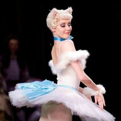 a woman dressed in white and blue posing for the camera