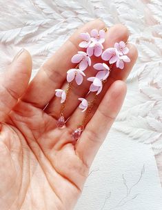 a person holding some pink flowers in their hand