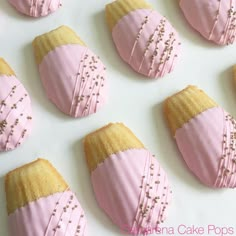 pink and gold decorated cookies on a white surface