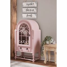 a pink cabinet sitting on top of a wooden floor