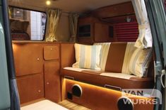 the inside of a camper with couches and pillows on it's side