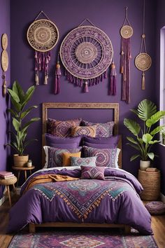 a bed with purple sheets and pillows in front of a wall decorated with hanging decorations