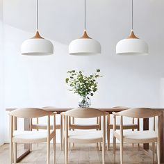 a dining room table with four chairs and a vase filled with flowers on top of it