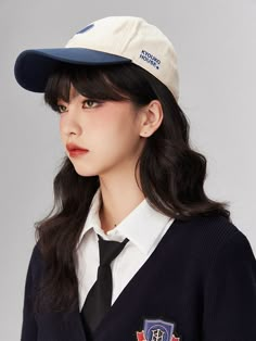 a woman wearing a hat and tie with patches on her sleeves is posing for the camera