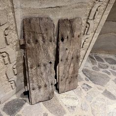 two wooden doors sitting next to each other on a stone floor