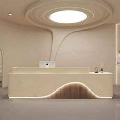 the interior of a modern office with white walls and ceiling lights on either side of the reception desk