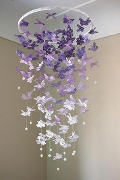 a wind chime with purple and white butterflies hanging from it's centerpiece