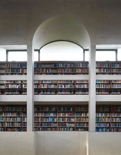 the interior of a public library with rows of books on shelves and arched doorways