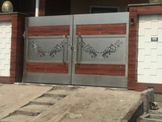 two metal gates with designs on them in front of a building