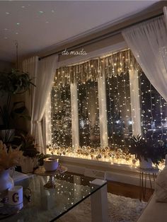 a living room filled with lots of lights next to a window covered in white curtains