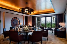 a dining room table with chairs around it and a chandelier hanging from the ceiling