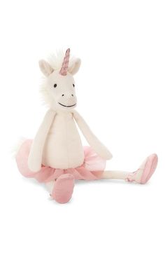 a white stuffed unicorn sitting on top of a pink ballerinas tutule