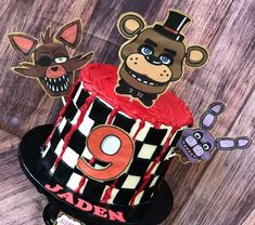 a birthday cake decorated to look like an animal with the number nine on it and two cartoon characters