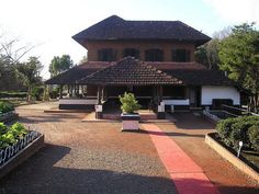 an old building with many plants in front of it and trees around the outside area