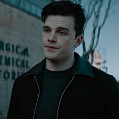 a man standing in front of a brick wall with the words america's chemical laboratory written on it