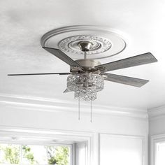 a ceiling fan with crystal chandelier hanging from it