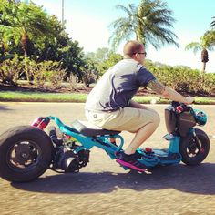 a man is riding an electric scooter down the street with palm trees in the background