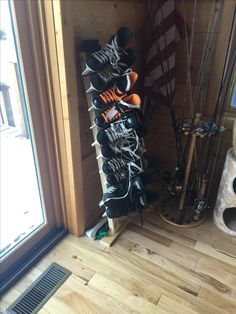 there are many pairs of skis and snowboards on the shelf next to the door