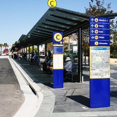 people are sitting on benches at the bus stop