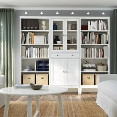 a living room filled with furniture and bookshelves next to a white couch in front of a window