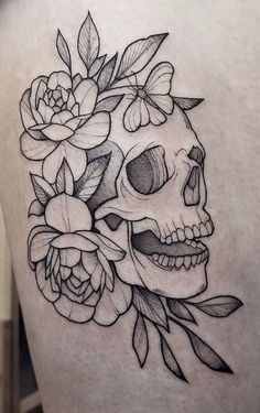 a woman's thigh with a skull and flowers on it