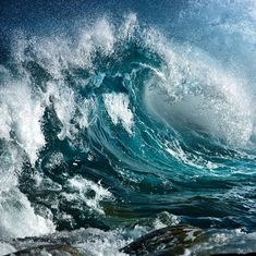 an ocean wave is breaking over the rocks