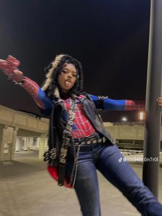 a woman dressed as spider - man poses for a photo in front of a street sign