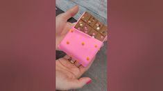 a hand holding a chocolate bar shaped like a cell phone case with candy on it