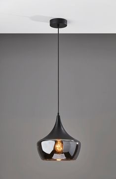 a black light fixture hanging from the ceiling in a room with grey walls and flooring