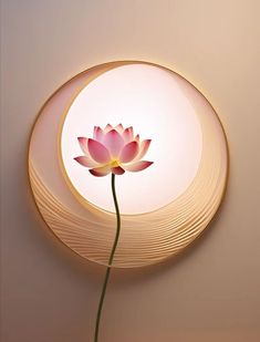 a pink flower sitting in front of a circular light