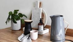 a wooden table topped with different types of kitchen appliances and pots on top of it