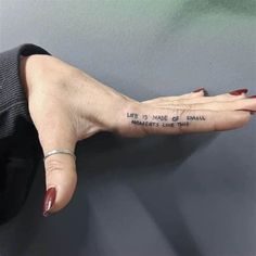 a woman's hand with a tattoo saying life is more than words on it