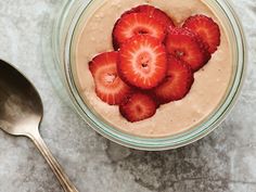 some strawberries are placed in a bowl with oatmeal on the side