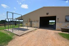 a large building with a metal gate in front of it and grass on the other side