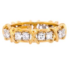 Circa 1980s, 18k, by Jean Schlumberger for Tiffany & Co. Iconic Tiffany style at its Schlumberger best! This 16-stone ring features a traditional ribbon of X's and diamond O's. A rather rare, all-yellow gold version, this one is a size 6. Schlumberger's visionary designs honored the Tiffany tradition while creating a dazzling new body of work. This ring is an older version, with a bit more diamond weight (1.50 carats of F color and VS clarity) than the new ones. Beautifully made, it is in excell Bunny Mellon, Jean Schlumberger, Tiffany Rings, Stone Diamond Ring, Diana Vreeland, Tiffany Style, Tiffany And Co, Vintage Band, Fine Silver