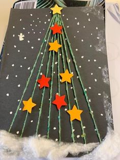 a christmas tree made out of paper on top of a piece of felt with stars